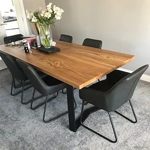 a wooden table surrounded by black chairs in a room
